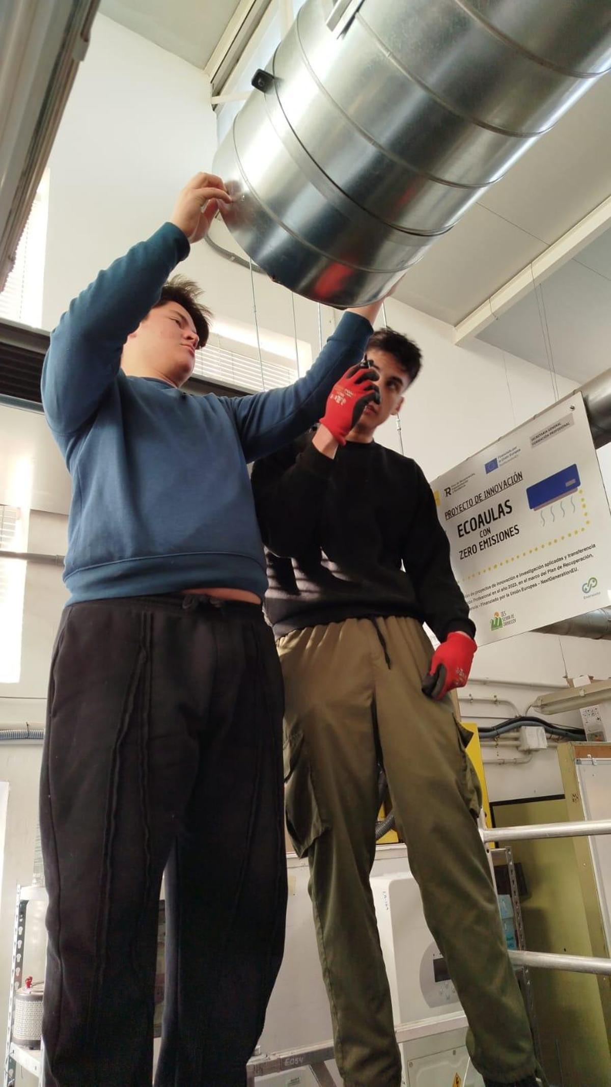 Dos alumnes de l'FP muntant les noves instalacions, que es convertiran en espais sostenibles