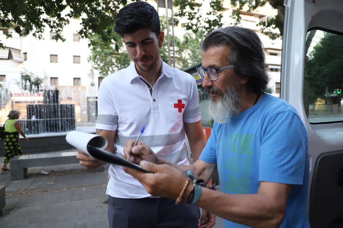 Javier Alférez atiende a un hombre en la para del bulevar de Gran Capitán.