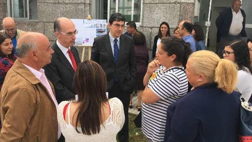 El alcalde Iglesias, el conselleiro Vázquez Almuíña y el delegado de la Xunta López-Chaves conversan con vecinas junto al centro. // FdV