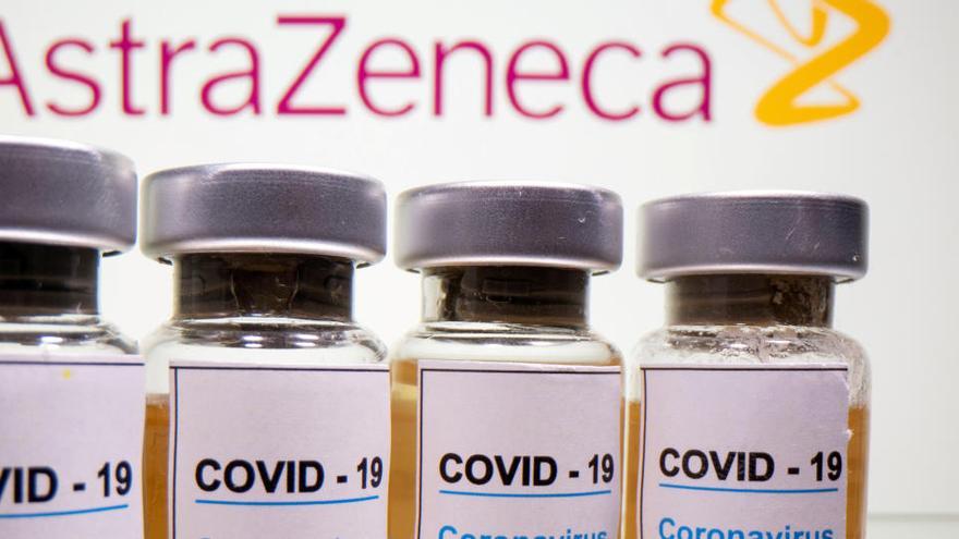 Vials amb una etiqueta adhesiva, &quot;COVID-19 / vacuna contra el coronavirus / només injecció&quot; i una xeringa mèdica davant del logotip d&#039;AstraZeneca