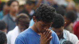 Un joven de la caravana reza en una ceremonia religiosa antes de llegar al puente fronterizo de Tecun Uman, Guatemala, este domingo.