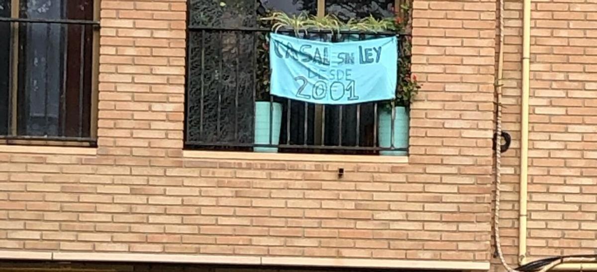 Cartel en el balcón de la vecina que ha demandado a la falla Parc de Trénor en Torrent: "Casal sin ley desde 2001".