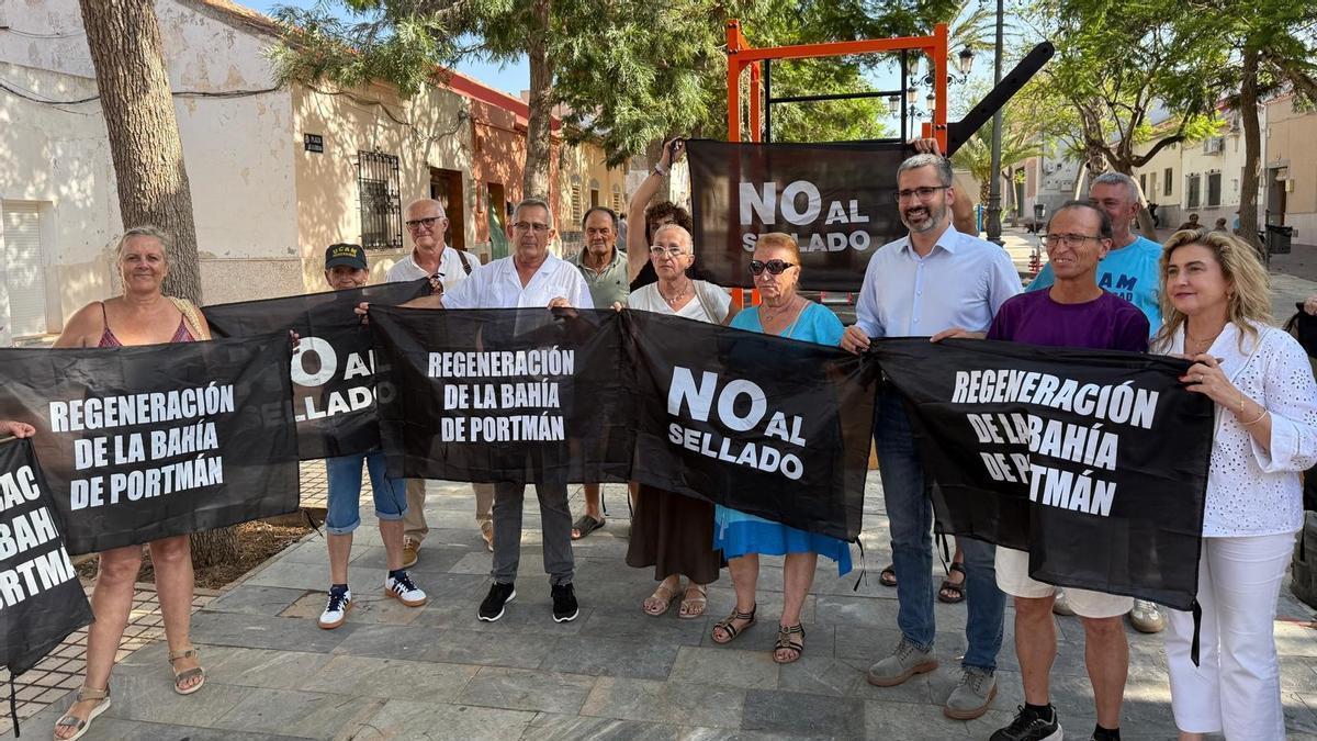 El delegado del Gobierno, Fransico Lucas, junto a vecinos de Portmán con pancartas de no al sellado de la bahía.