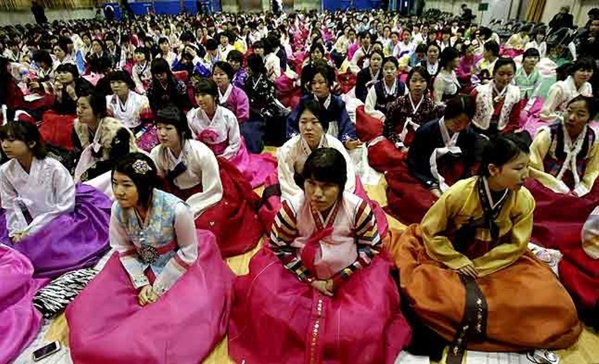 Noies sud-coreanes, amb vestits tradicionals, participen en una cerimònia conjunta de graduació i de majoria d’edat, al Dongmyung Girls’ High School a Seül (Corea del Sud).