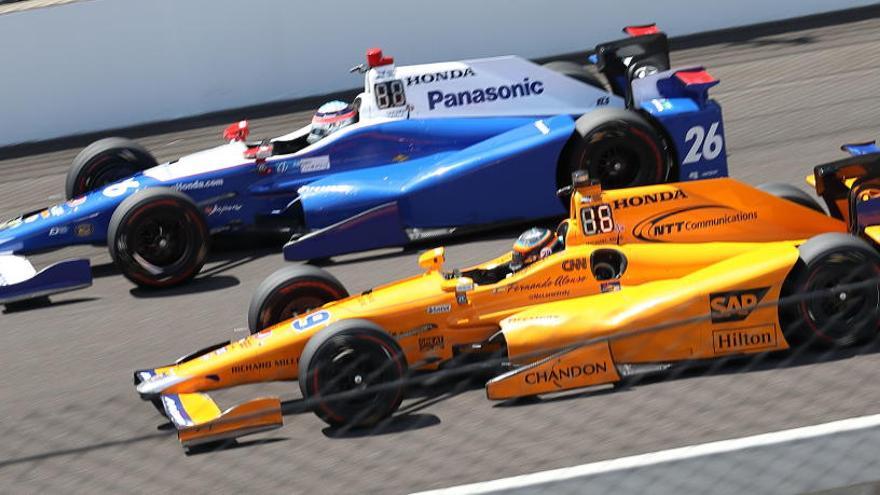 Alonso, en el coche naranja de McLaren, junto a otro competidor.