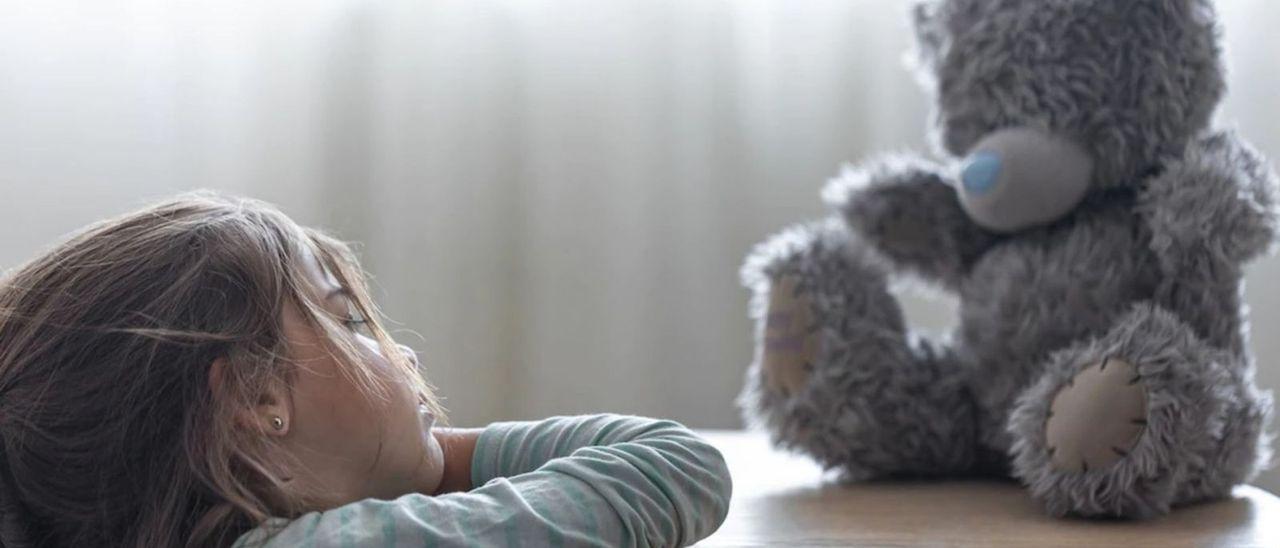 Una niña con su peluche.