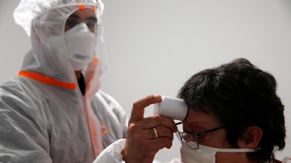 Un mÃ©dico francÃ©s toma la temperatura a una paciente.