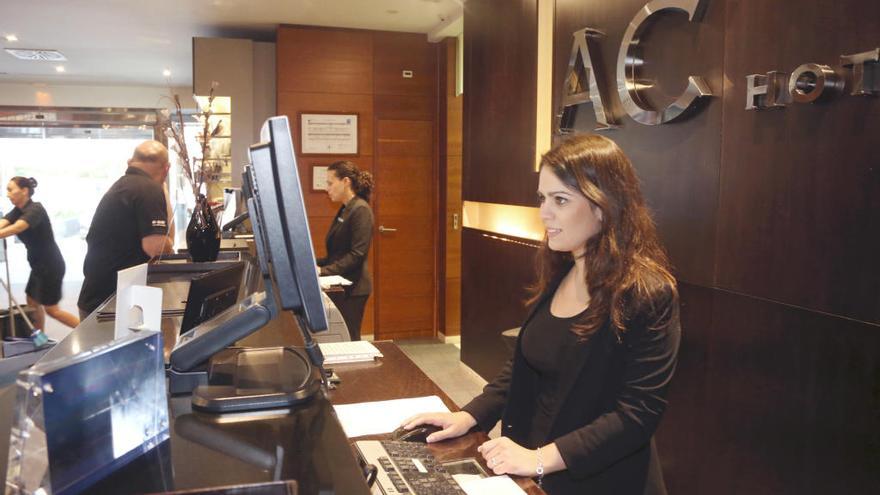 Una recepcionista atiende las reservas de un hotel en Murcia.