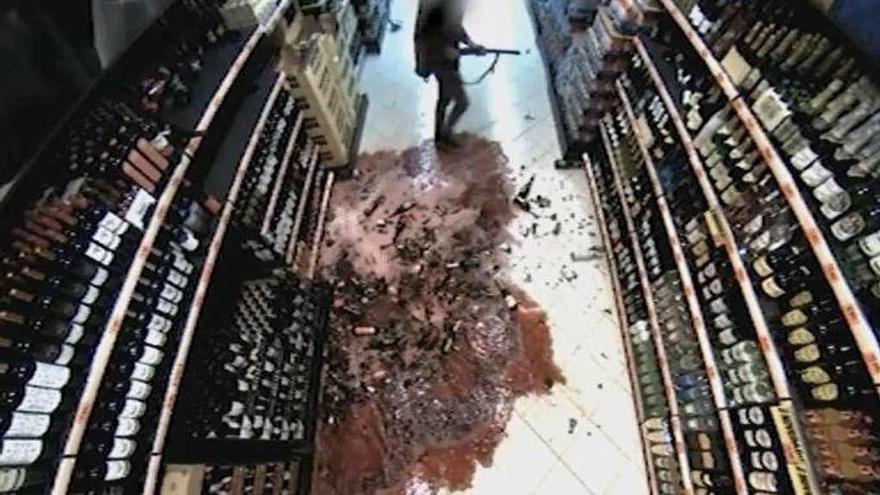 Las cámaras captaron el momento en el que el asaltante rompió las botellas de vino. // FdV