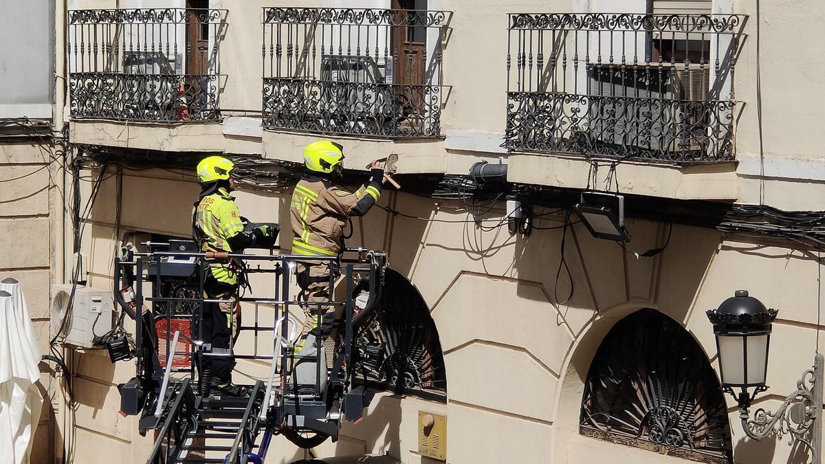 Los bomberos cincelan uno de los voladizos del edificio número 8 de la plaza.