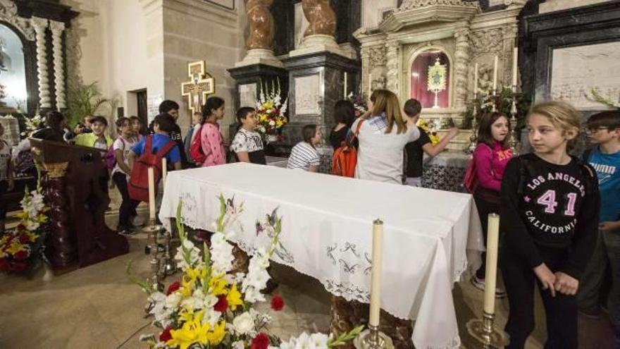 Escolares pasan por delante de la Reliquia que se venera en el monasterio desde hace más de 500 años, ayer.