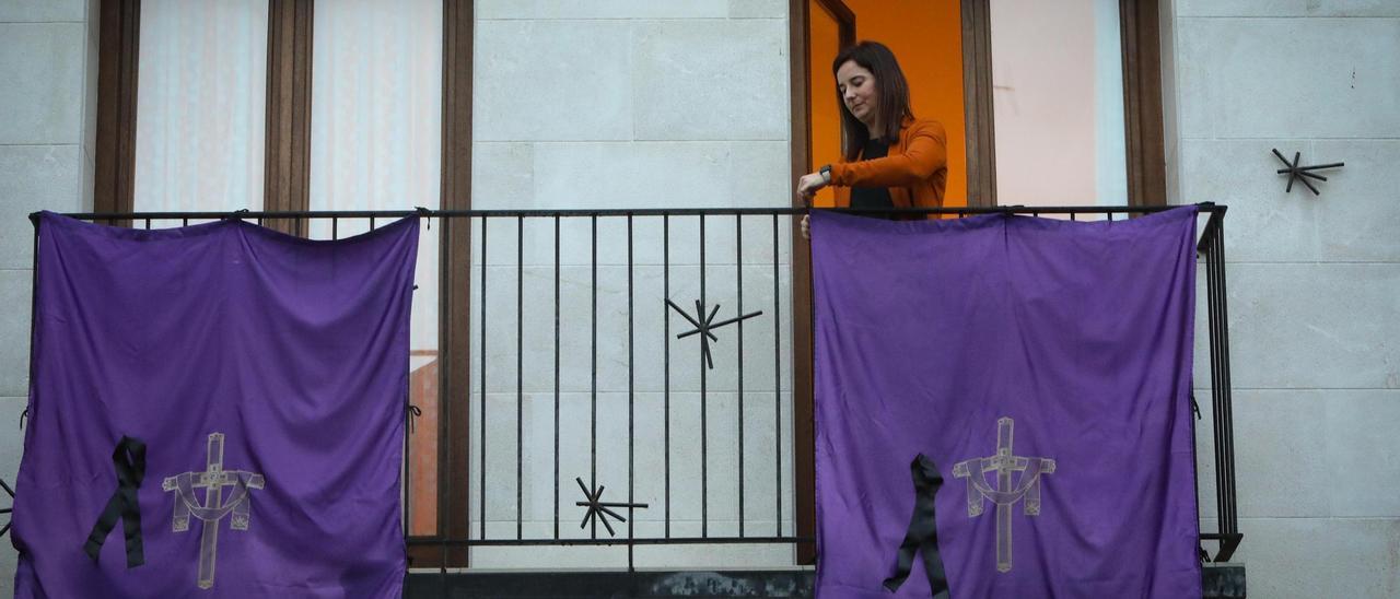 Una vecina retocando las banderolas de Semana Santa, con los crespones.