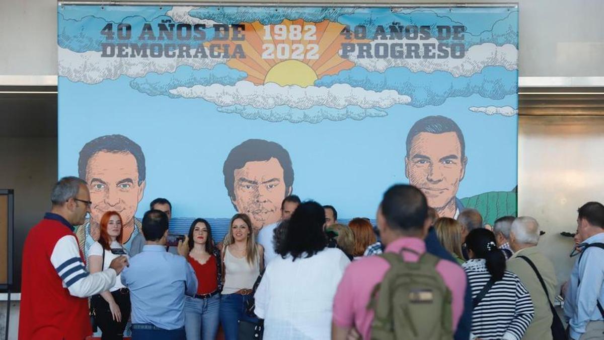 Asistentes al acto del 40 aniversario de la victoria de Felipe González con el PSOE posan junto a un cartel.