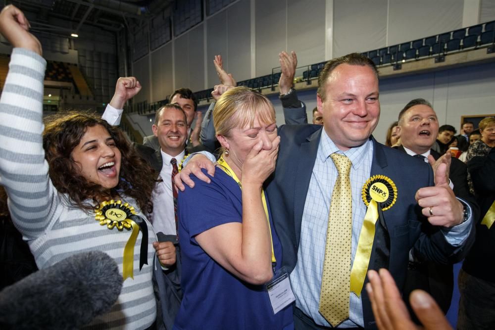 El diputado del Partido Nacional Escocés Chris Stephens (d) celebra con su esposa, Aileen Stephens (i), después de que ganó el asiento del oeste de Glasgow.