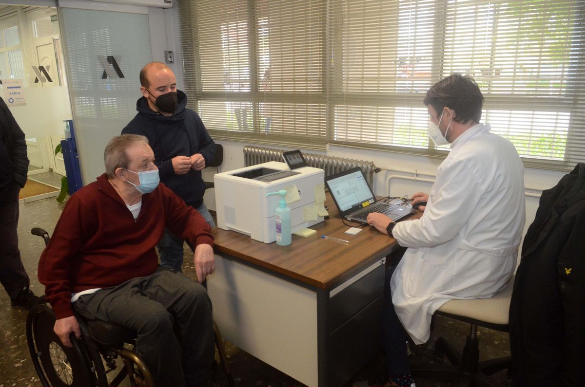 El personal administrativo atiende a un paciente a su entrada al centro de vacunación.