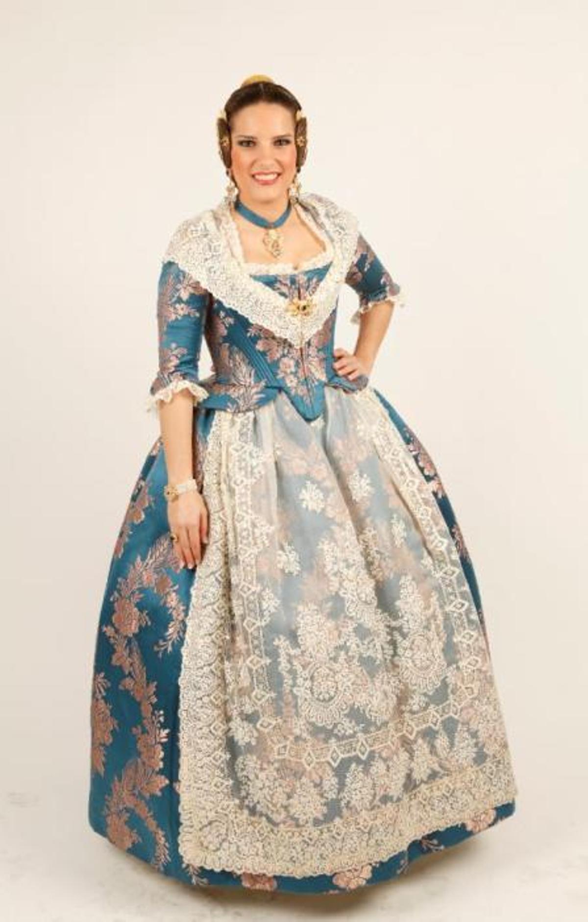 ¿Que detalle destacó? Sobre todo destaca por el contraste de los colores, el azul prusia con el rosa bebe. Lo lleva combinado con un aderezo en color azul montana exclusivo de Peris Roca «padre» El juego de collar y pendientes es un diseño antiguo y tiene su miga: llevaba la piedra en cuadrado y para completarlo tuvieron que añadirle al resto de aderezo la piedra en forma redonda. El anillo hace juego con el aderezo. Por cierto, la joia tiene forma similar a los pendientes, engastando dos de manera horizontal.