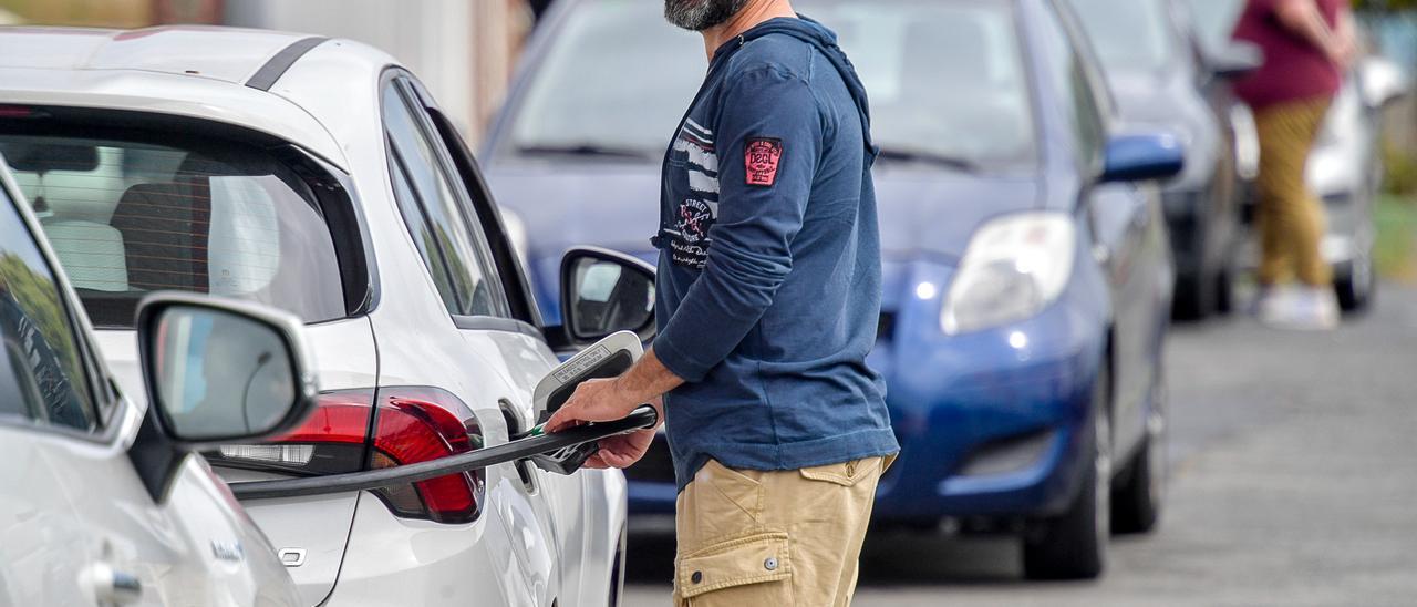 Un conductor reposta su vehículo en una gasolinera.