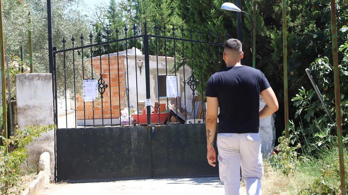 Un joven observa la vivienda ya precintada por la Policía.