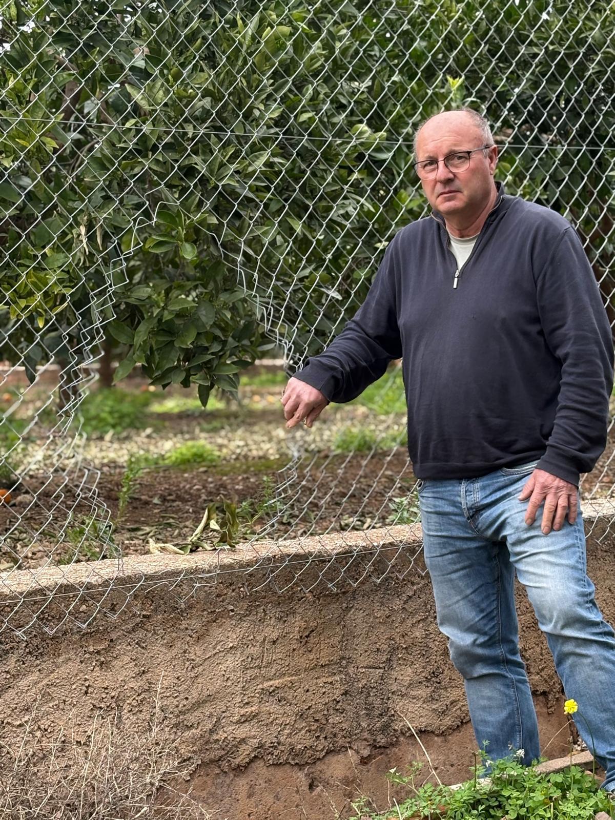 José Luis Furió muestra el agujero en su valla por donde entraron los ladrones.