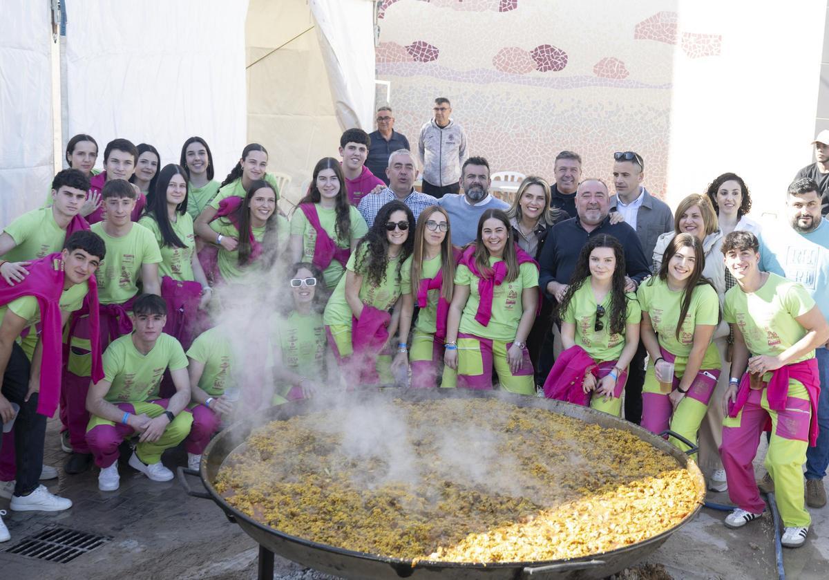 Foto de familia delante de la paella.