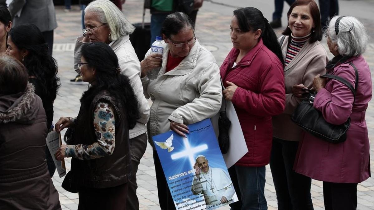 Feligreses esperan la llegada del Papa Francisco en las inmediaciones de la catedral de Bogotá.