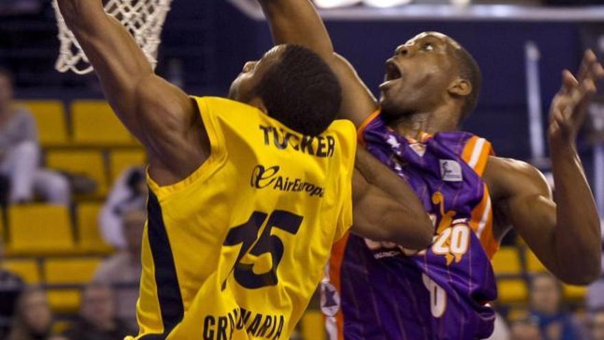 El alero estadounidense del Gran Canaria 2014, Alando Tucker (i), entra a canasta ante el ala pívot francés del Valencia Basket, Florent Pietrus, durante el partido de la décimoquinta jornada de la Liga que disputaron hoy en el Centro Insular de Deportes de la capital grancanaria.