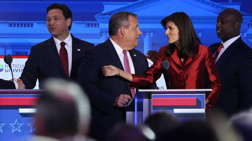Chris Christie habla con Nikki Haley, con Ron DeSantis y Tim Scott al fondo, durante el debate de candidatos republicanos.