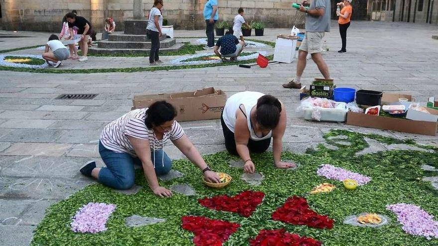 Trabajos de elaboración de alfombrados florales en la avenida de Santa María. // Rafa Vázquez