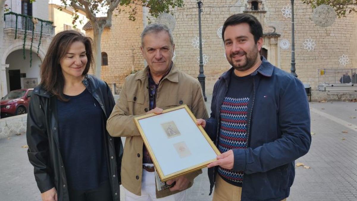 El alcalde de Alaró (derecha) recibe la fotografía más antigua sobre los Cossiers junto a Joana Borràs y Rafel Pons.
