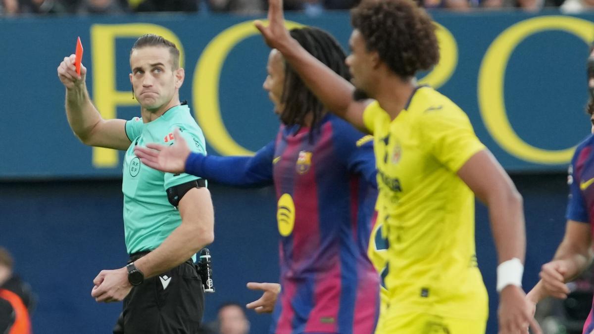 The referee shows a red card to Villarreal's Renato Veiga, right, during the Spanish La Liga soccer match between Villarreal and Barcelona in Villarreal, Spain, Sunday, Dec. 21, 2025. (AP Photo/Alberto Saiz)