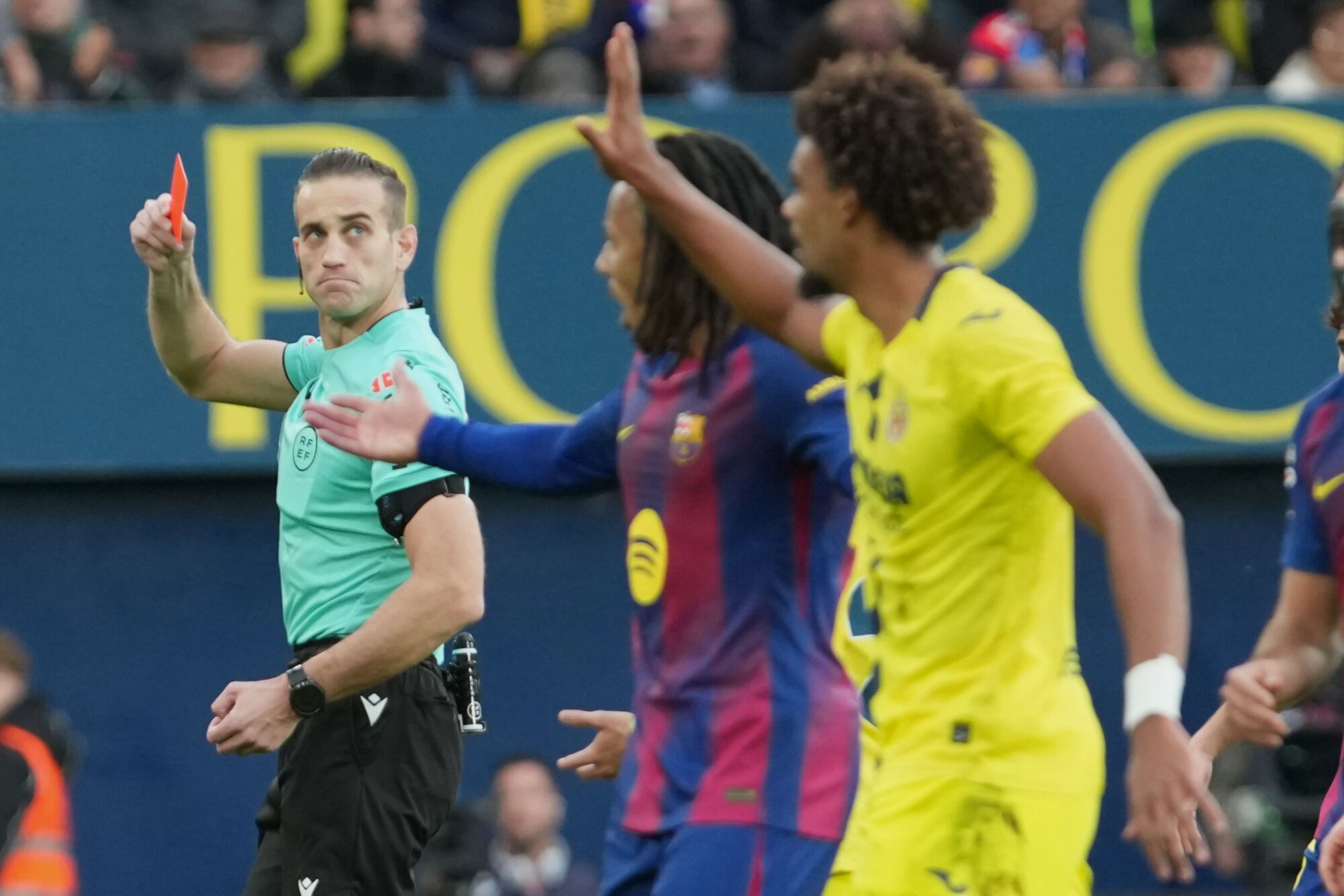 The referee shows a red card to Villarreal's Renato Veiga, right, during the Spanish La Liga soccer match between Villarreal and Barcelona in Villarreal, Spain, Sunday, Dec. 21, 2025. (AP Photo/Alberto Saiz)