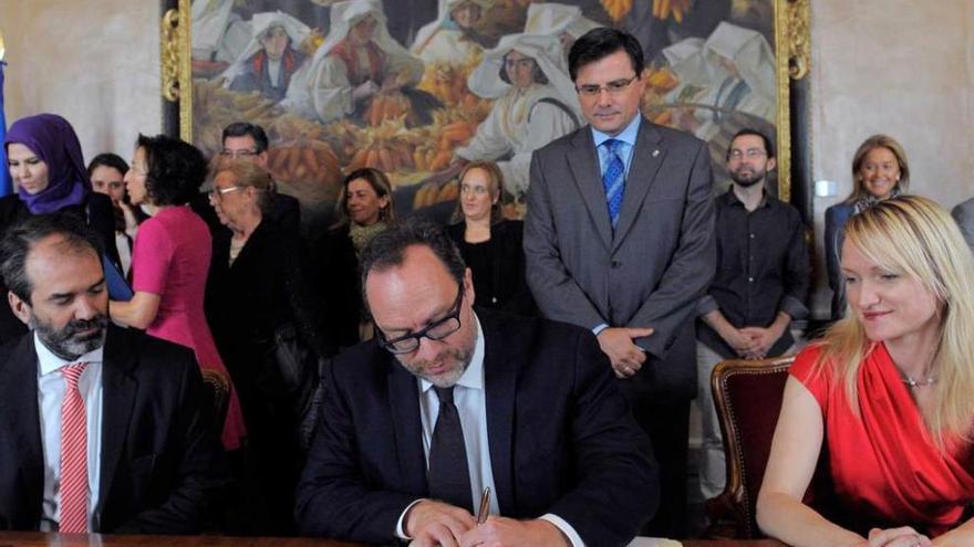 Patricio Lorente, Jimmy Wales y Lila Tretikov, firmando en el libro de honor; tras ellos Pedro Sanjurjo y los portavoces parlamentarios.