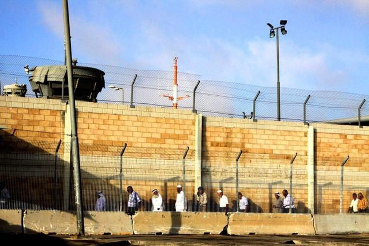 Els homes s’endinsen per un passadís enreixat a la terminal de Kalandia. A cadascun dels controls han de mostrar la seva cèdula d’identitat o el permís especial per entrar a Jerusalem