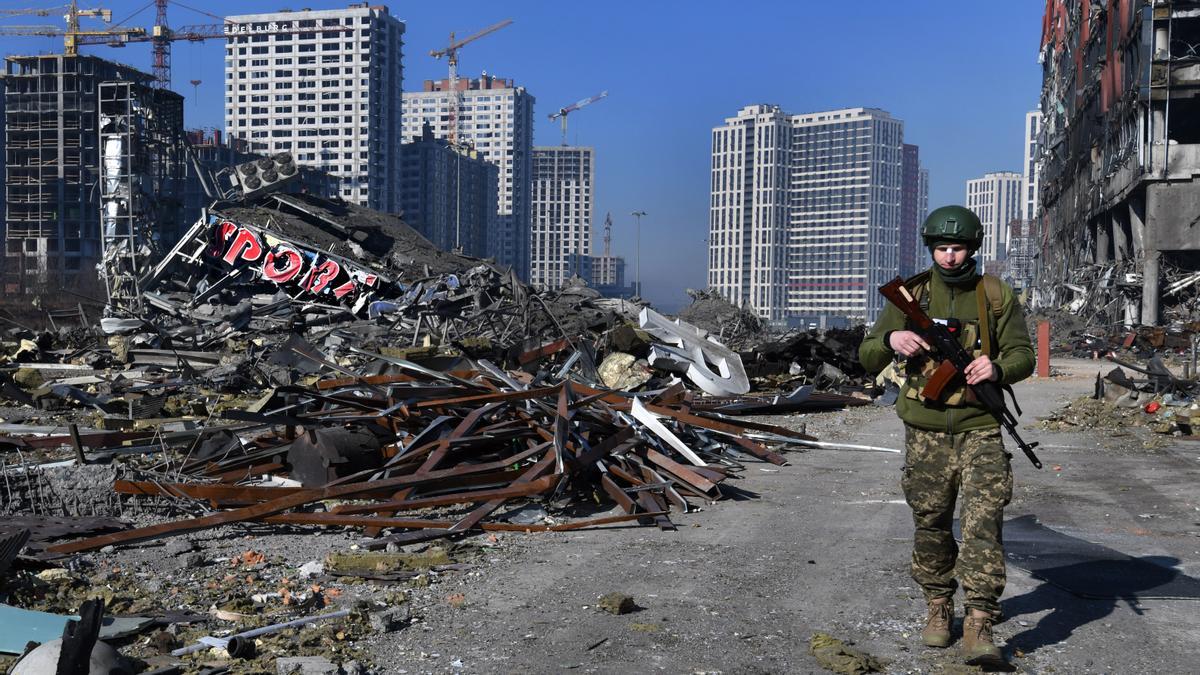 Un soldado ucraniano camina junto a un centro comercial destruído en Kiev