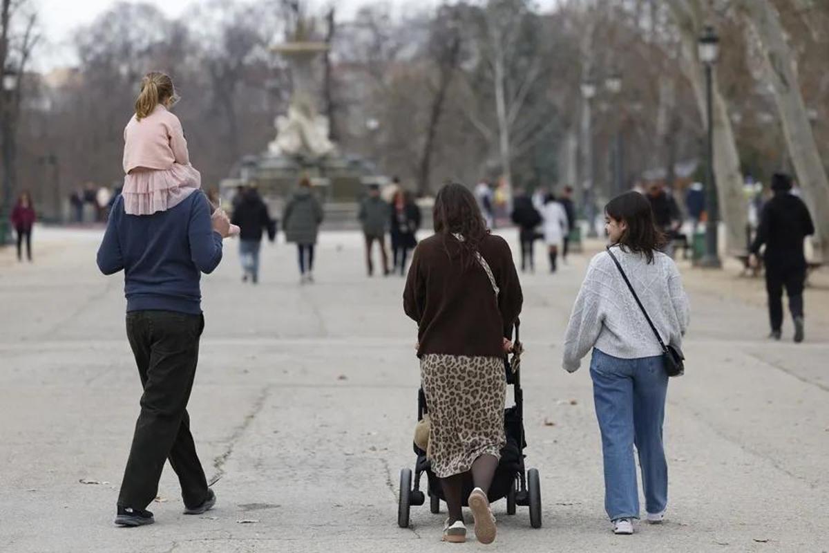 Una familia pasea por el parque durante el invierno.
