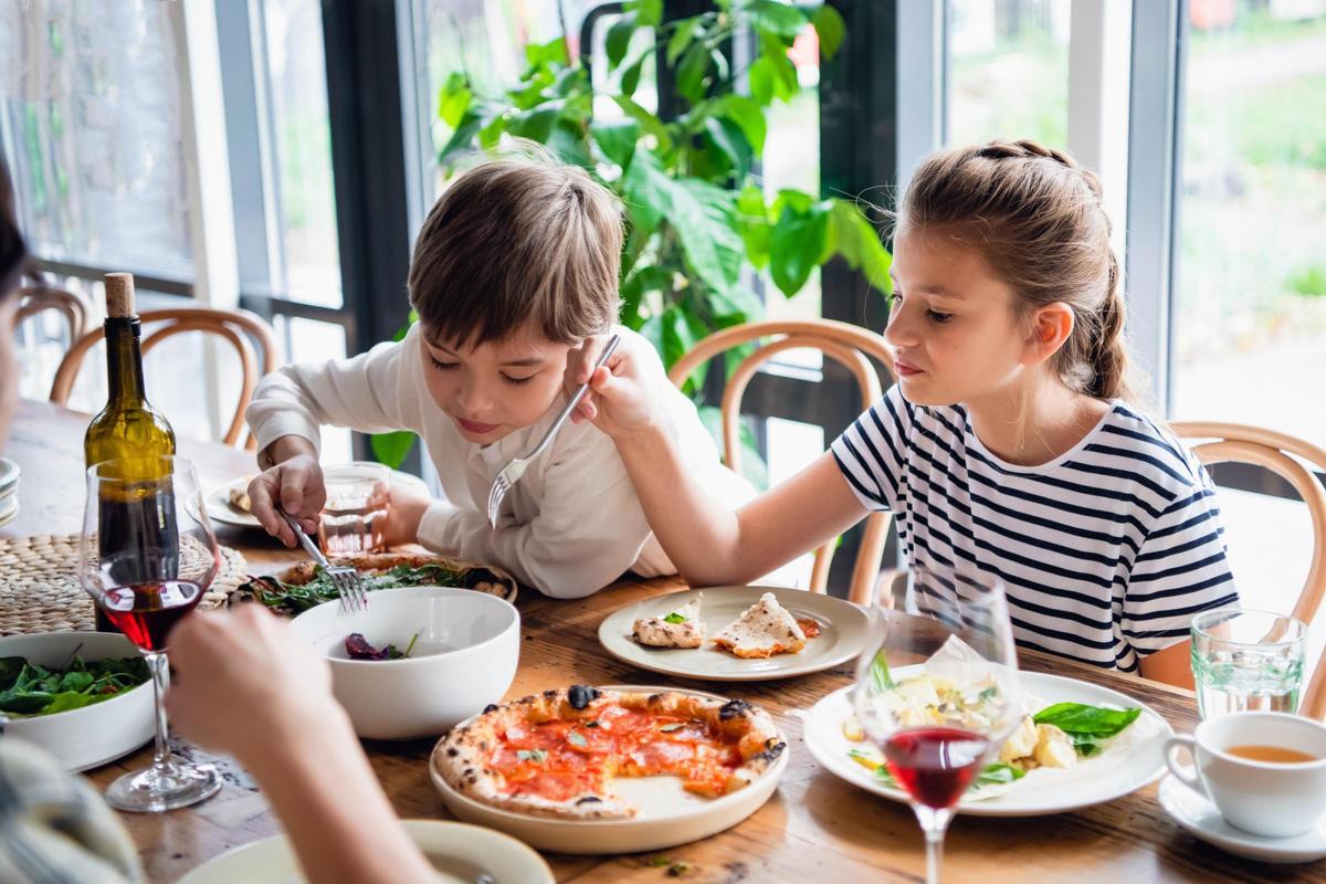 Dos niños sentados a la mesa para comer