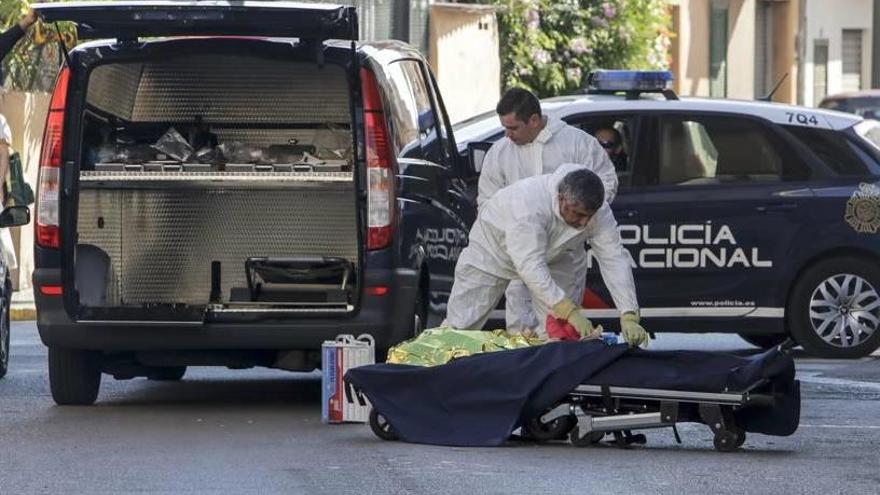 Los empleados de la Empresa Funeraria Municipal se disponen a introducir el cadáver en el furgón.