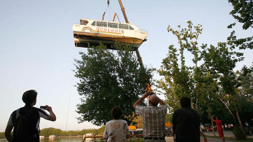 La grua eleva el catamarà per sobre dels arbres de l&#039;Estany davant la mirada de diversos veïns.