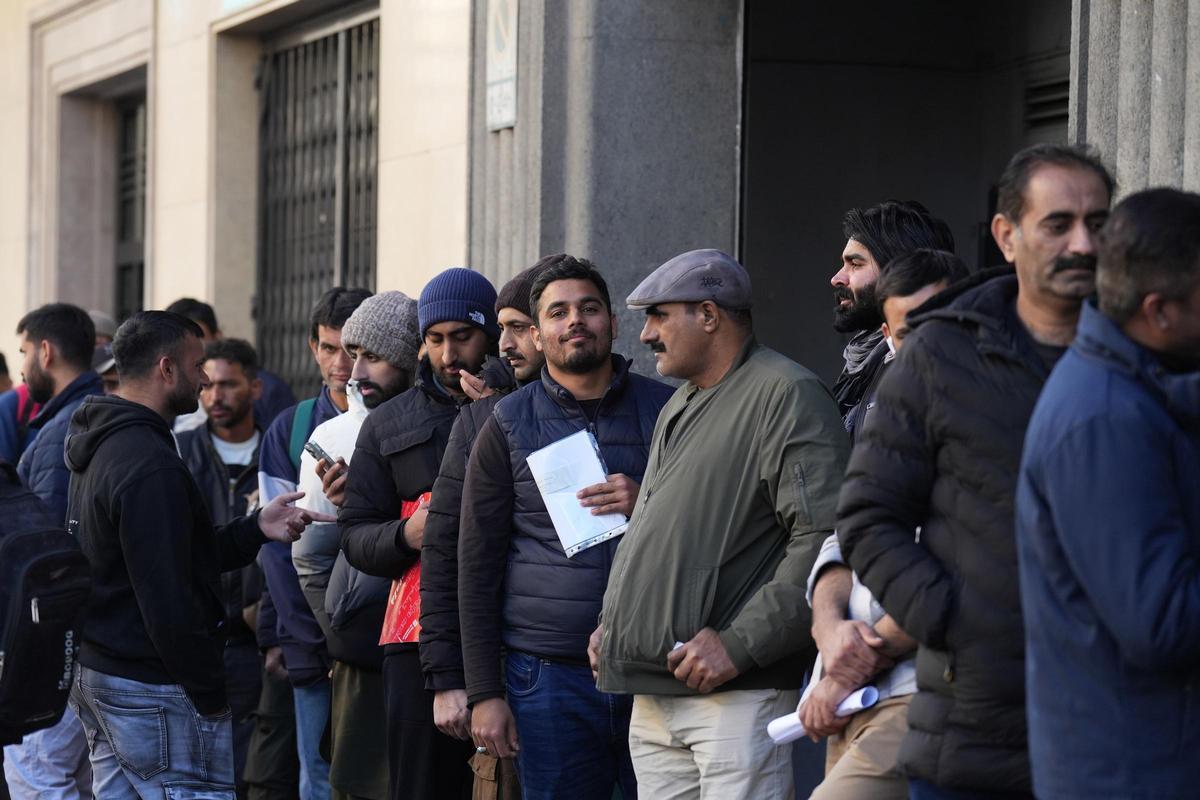 Imagen de archivo de migrantes haciendo cola para informarse por la regularización extraordinaria.