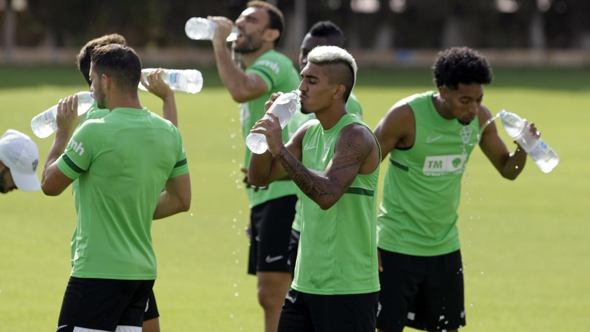 César Moreno, en el centro, bebe agua en un entrenamiento con el primer equipo junto a Marcone (i), Mojica (d) y Gonzalo Verdú, al fondo.