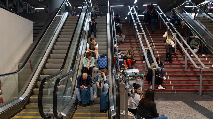 Viajeros atrapados en la estación de Atocha, anoche en Madrid. | EP
