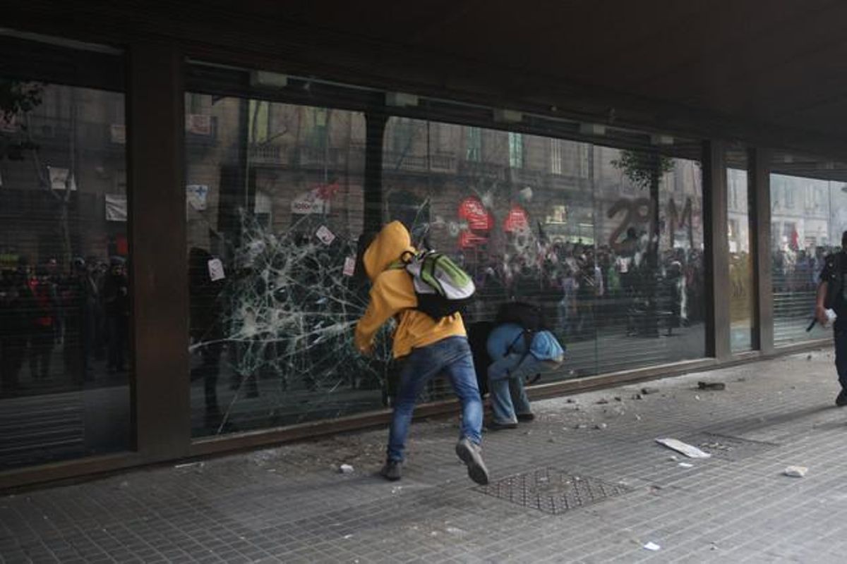 Unos alborotadores rompen un cristal de El Corte Inglés.