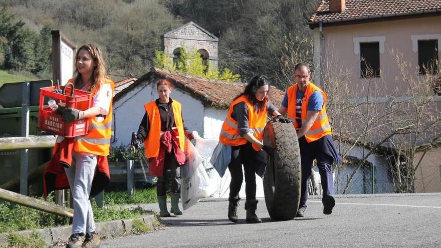 Un grupo de voluntarios llega al punto de encuentro con sacos, cajas y una rueda de tractor.