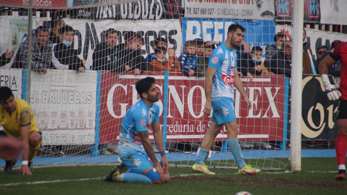 Juanjo Chavalés, a la derecha, tras recibir un gol el Coria.