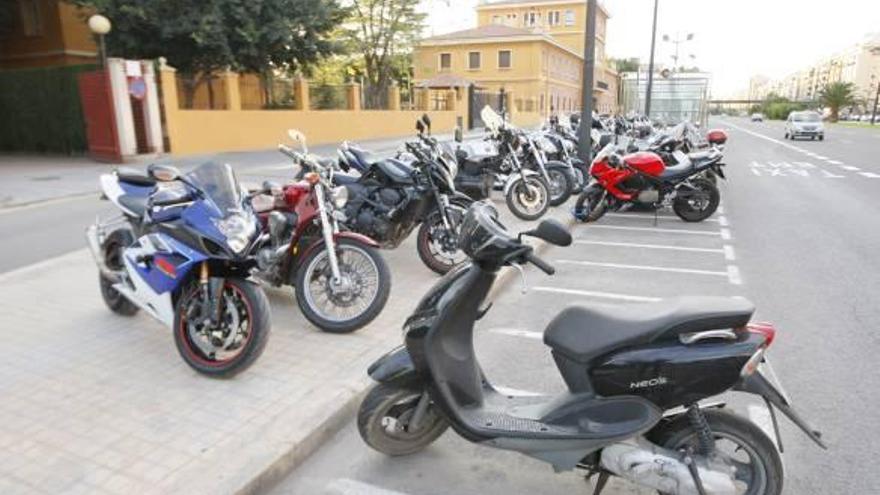 Motos aparcadas sobre la acera junto a la central de la Policía Local de Valencia.