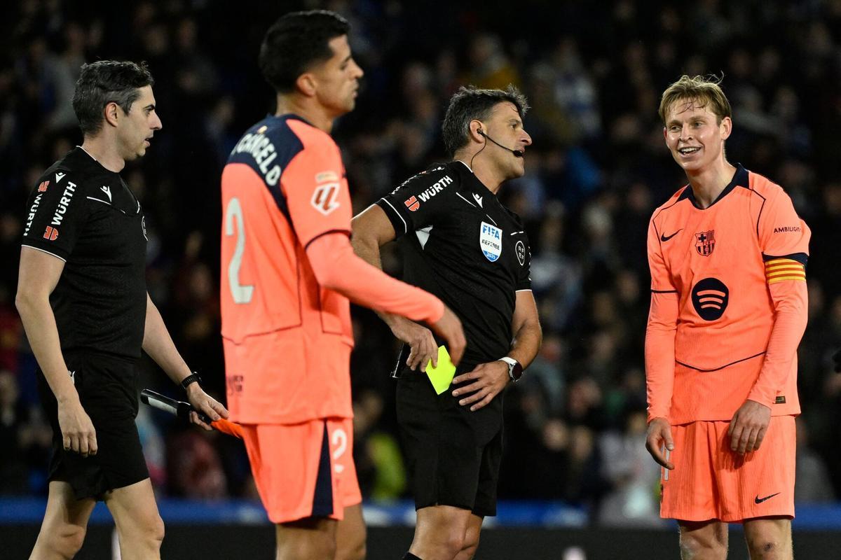 Frenkie de Jong recibe una amarilla del árbitro por protestar en Anoeta.