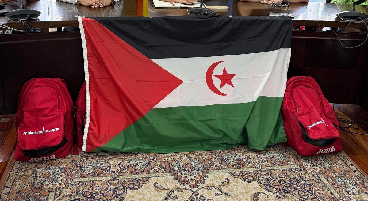 La bandera saharaui junto con las mochilas que regaló el Ayuntamiento a los niños participantes.
