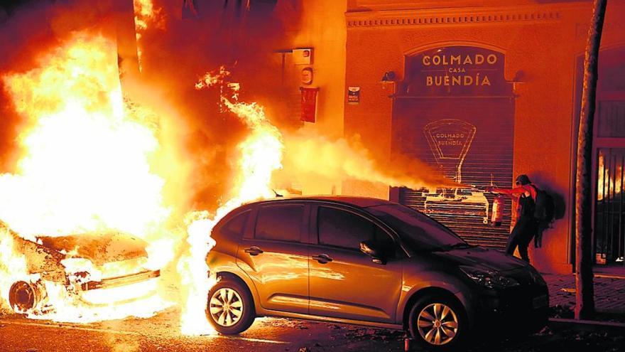 Dos de los vehículos incendiados anoche en Barcelona, en las inmediaciones de la Consejería de Interior.