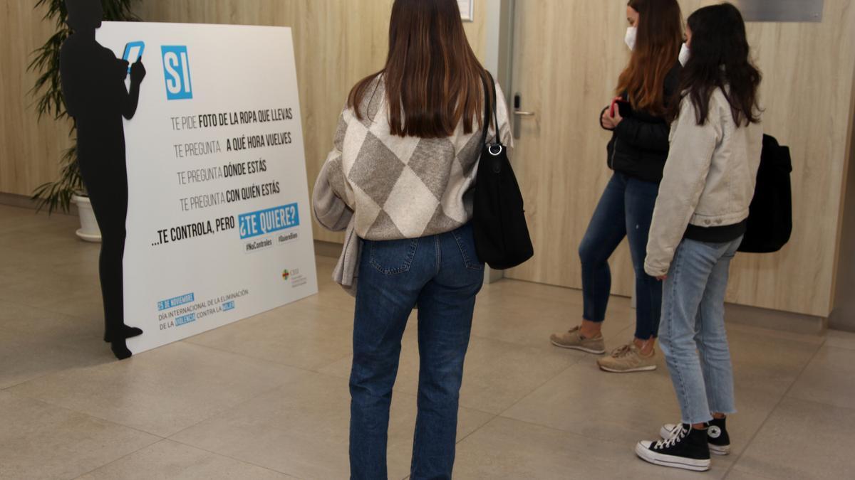 Unas estudiantes, leyendo un cartel de la campaña en el CEU San Pablo de Elche