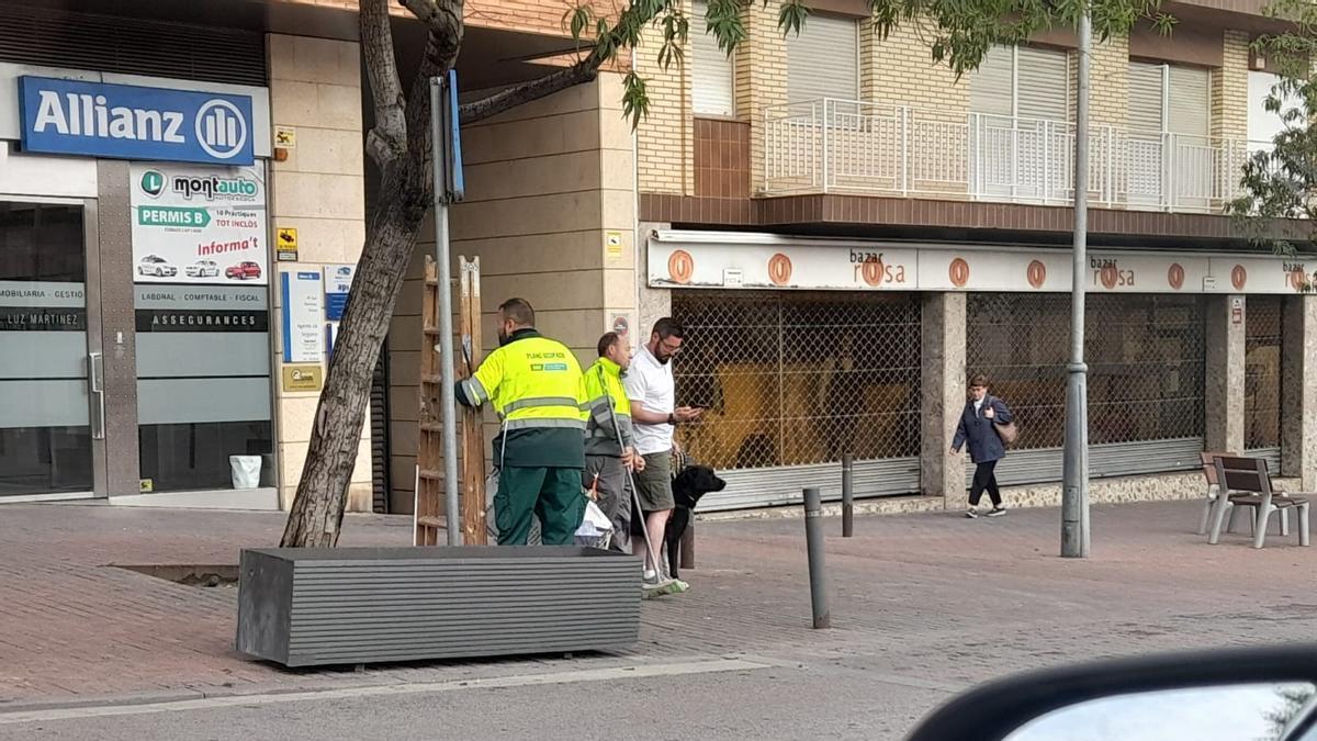 Treballadors de la brigada municipal despenjant cartells d'ERC a Santa Margarida de Motbui